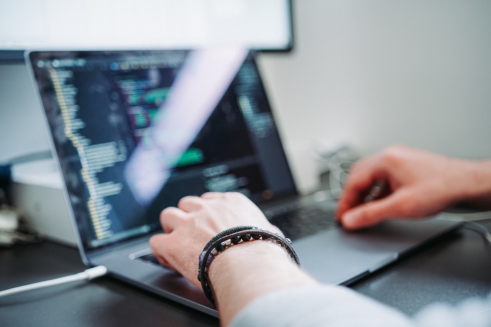 Image of person coding on a laptop.